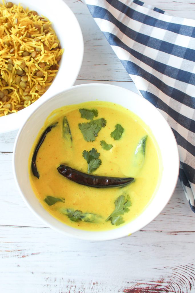 kadhi in a bowl topped with chili and cilantro