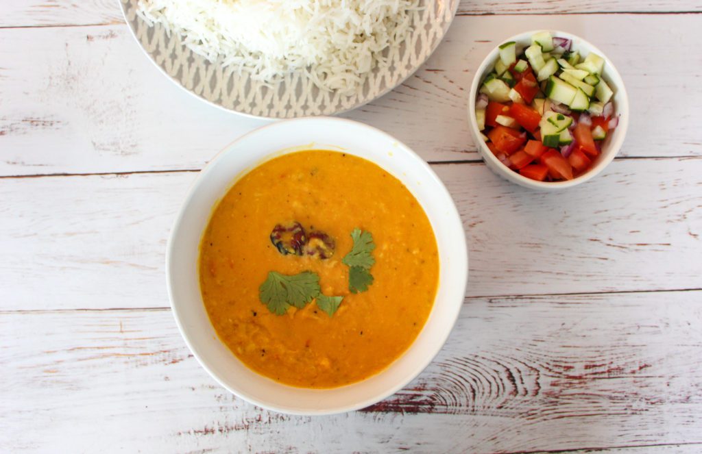 dal served in a bowl with basmati rice and a simple salad