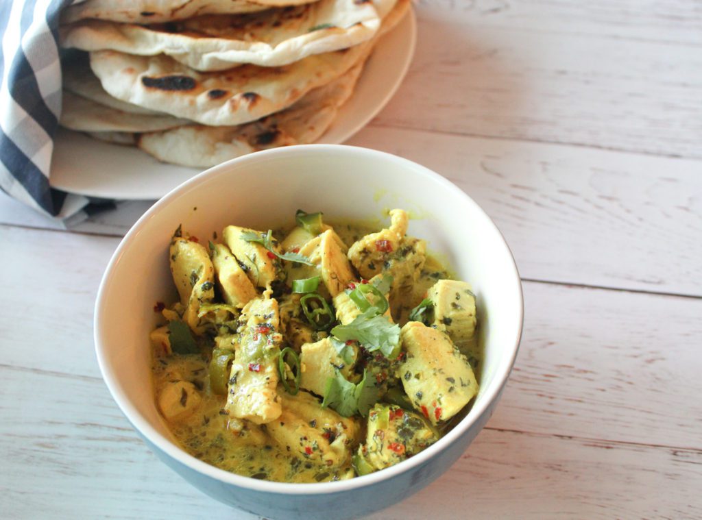 white chicken karahi in bowl with naan.