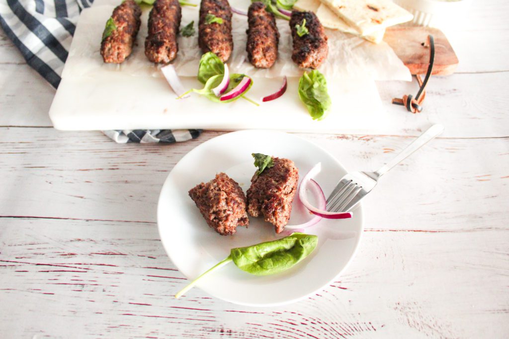 beef seekh kabab split into two on a small plate 