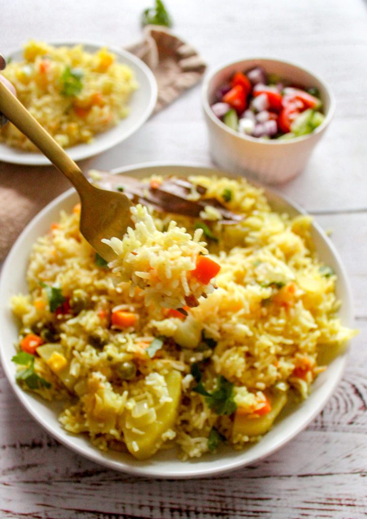 plate of vegetable pulao with a bite on a fork 