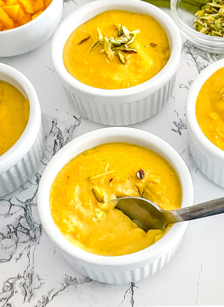 mango phirni served with a spoon