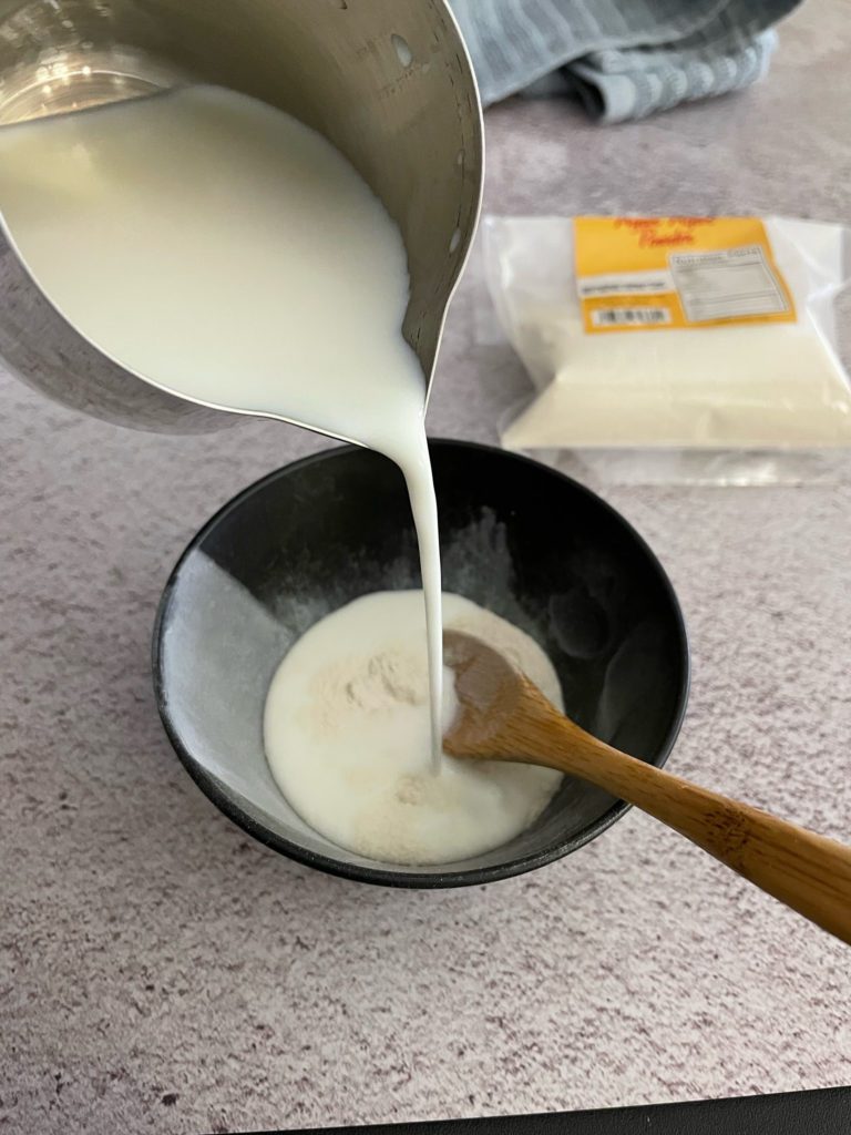 milk poured into a small bowl with spoon