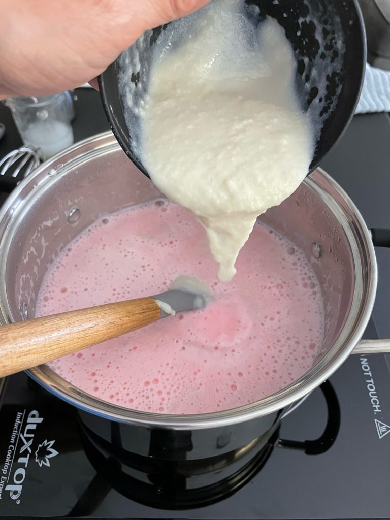 agar agar mixture being poured into milk mixture