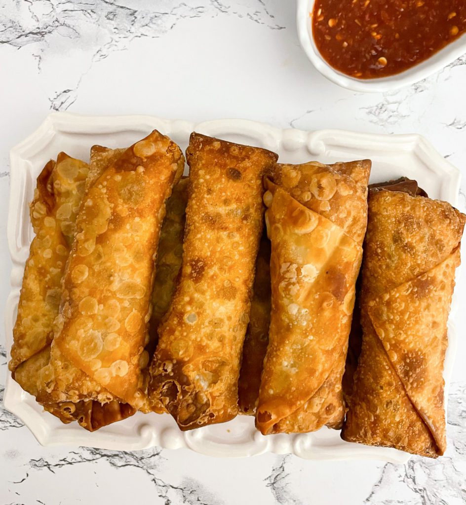 chicken egg rolls lined on a plate - overhead shot