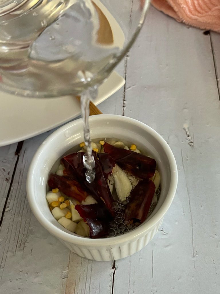 water poured into bowl with chili and garlic